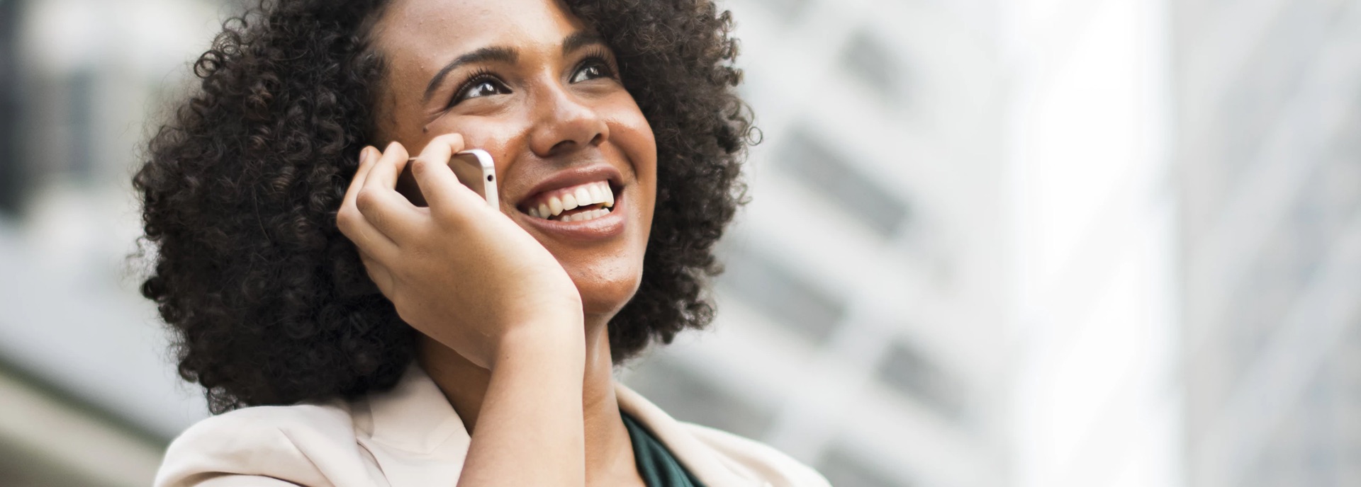 a black woman smiling while on the phone