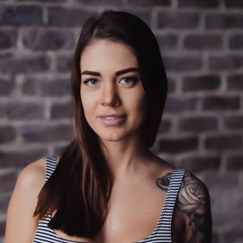 headshot of white woman with medium length brown hair wearing horizontal strip tank top